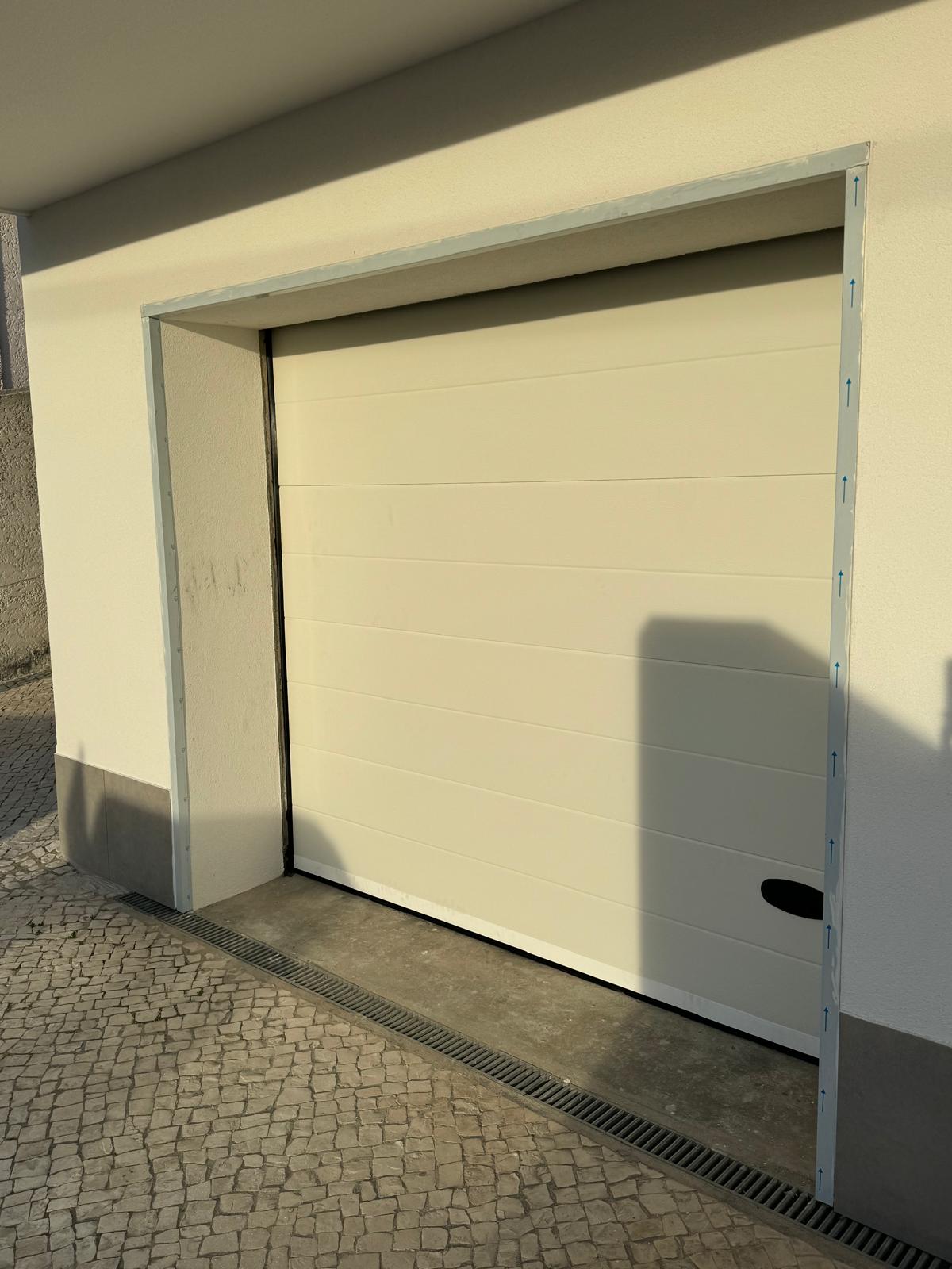 Porta seccionada de garagem branca, painel horizontal liso
